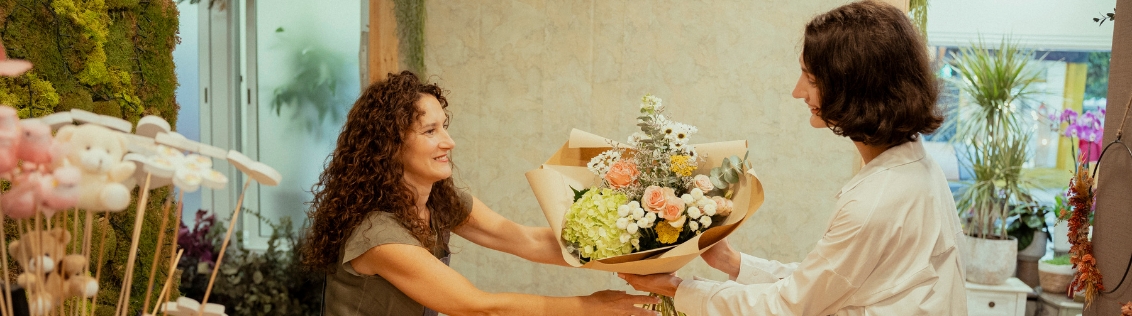 Busy flower shop counter with a florist point of sale system on screen