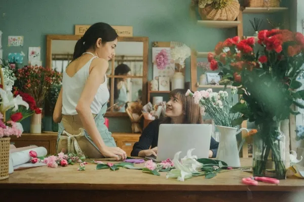 Florist preparing an online flower order at a shop counter